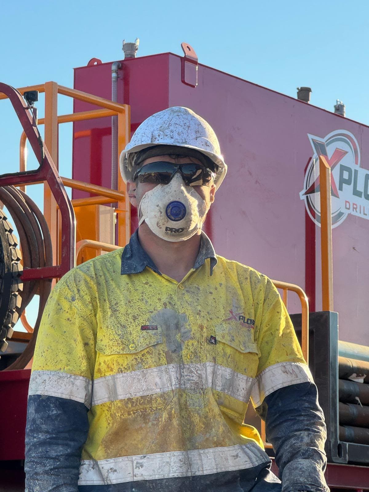 Xplore Drilling crew member beside a branded support truck